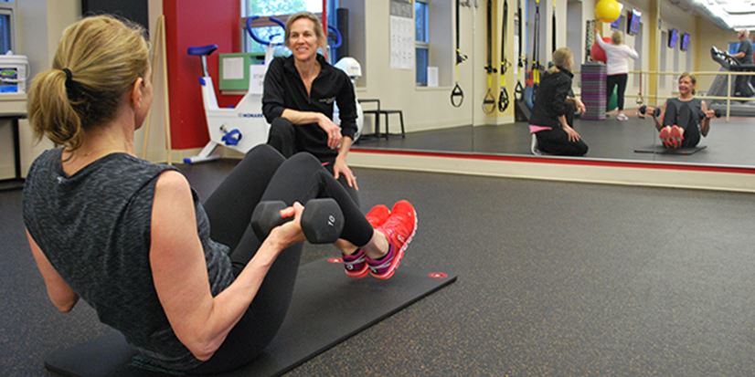 personal trainer working with a woman in a gym