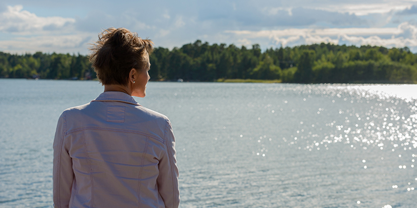 woman sitting by lake