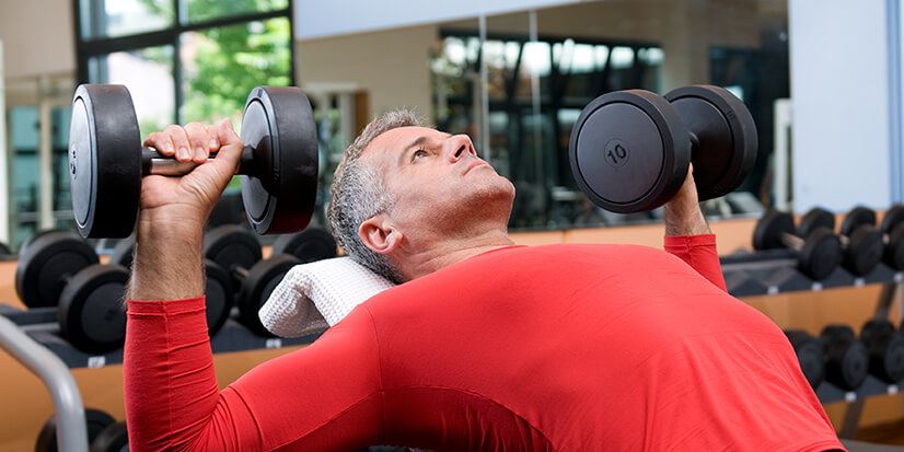 man doing chest press with dumbbells