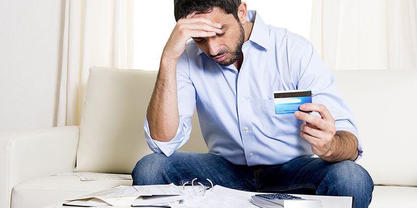 stressed man holding a credit card