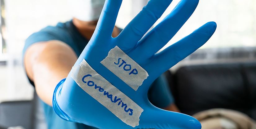 gloved hand with stop coronavirus written on it
