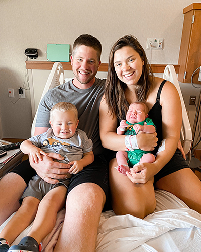 Family holds newborn and toddler