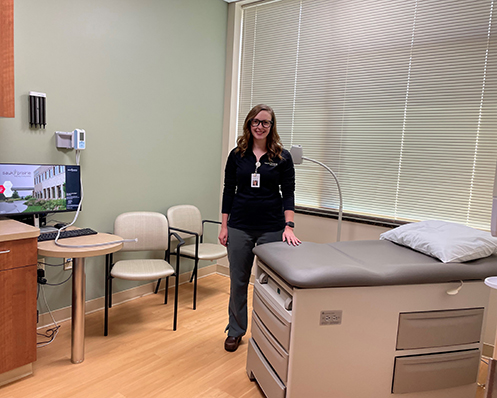 provider stands by table in clinic exam room