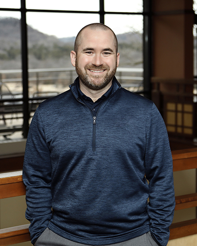 headshot of male in blue shirt