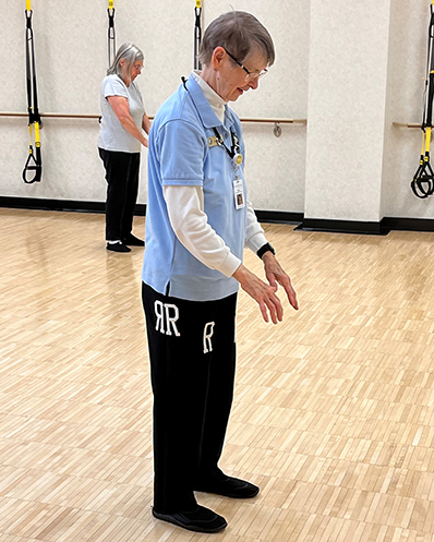 Peg leading a tai chi class at Wellspring