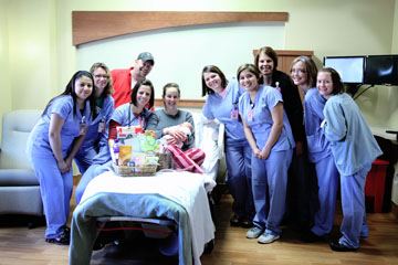 nurses standing around patient in bed