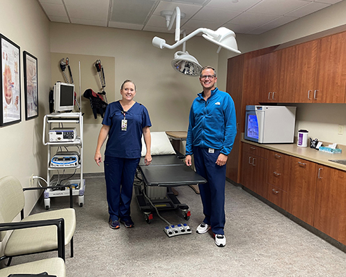 two providers stand by table in clinic room